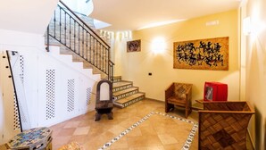A staircase leading to an upper floor, a wall-mounted artwork, and a red Coca-Cola cooler.