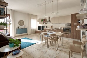A modern living room with a sofa, coffee table, and a dining area with chairs.