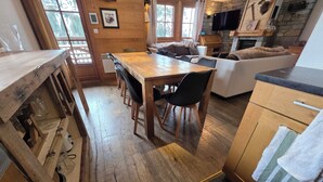 A rustic wooden interior with a dining area, sofa, and stone fireplace. - Typical chalet, combining the charm of wood and stone, overlooking the Isère river  (Tignes)