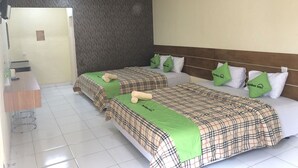 Ein Hotelzimmer mit zwei Betten, einem Empfangstresen und einer Wand mit Muster.