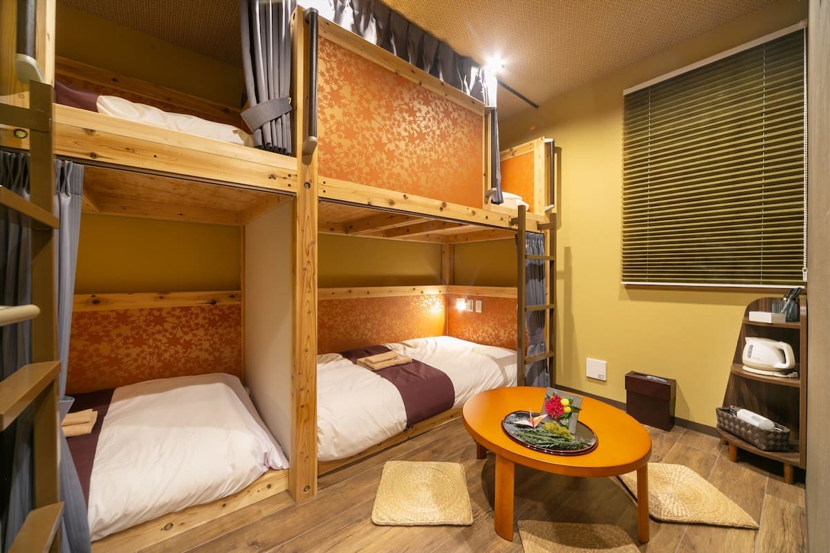 A bunk bed room with a table and a microwave.