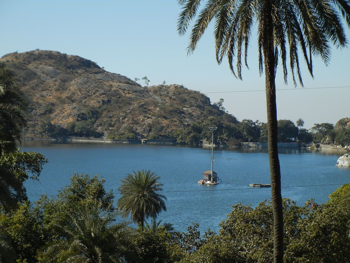 A calm lake with a small island and a lighthouse.