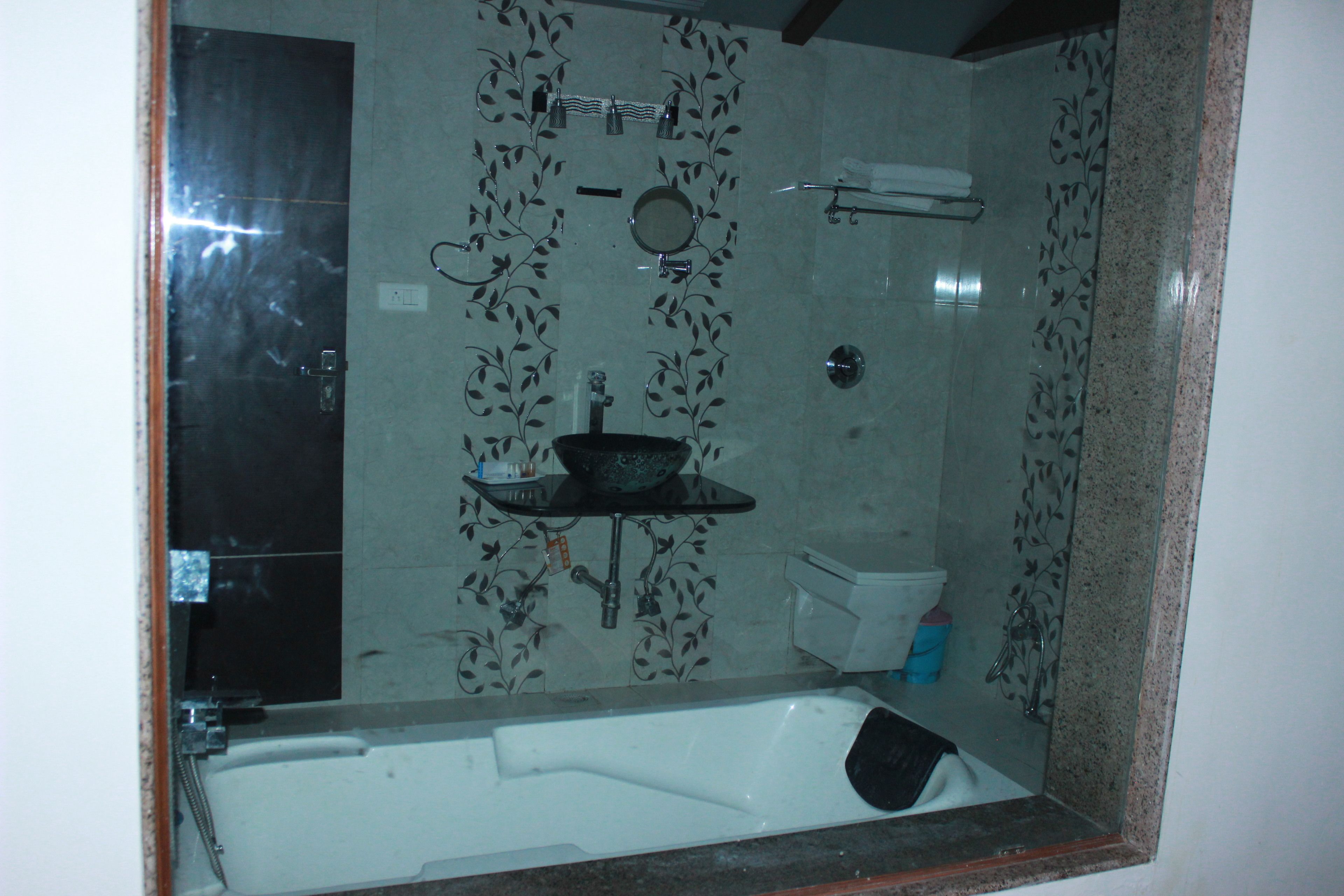 A bathroom with a bathtub, a sink, a mirror, and a toilet.