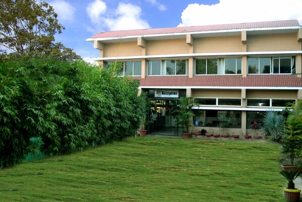 A two-story building with a reception area, surrounded by a well-maintained lawn and potted plants.