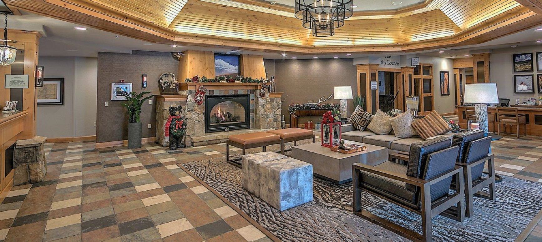 A spacious living room with a fireplace, a seating area with sofas and a coffee table, and a checkered floor.