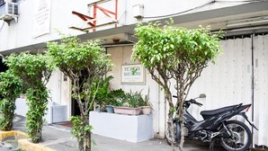 A building with a sign for 'Victoria Mansions' and a parked motorcycle.