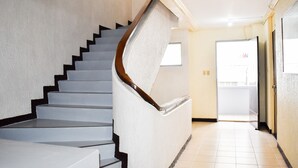 A staircase with a wooden handrail and white walls.