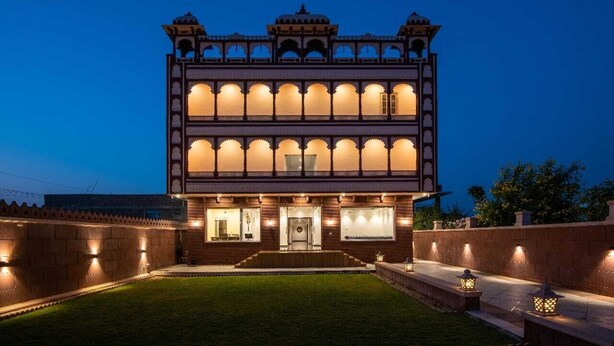 A multi-story building with a symmetrical facade, arched windows, and a central entrance. - Hotel The Balam (Luni)