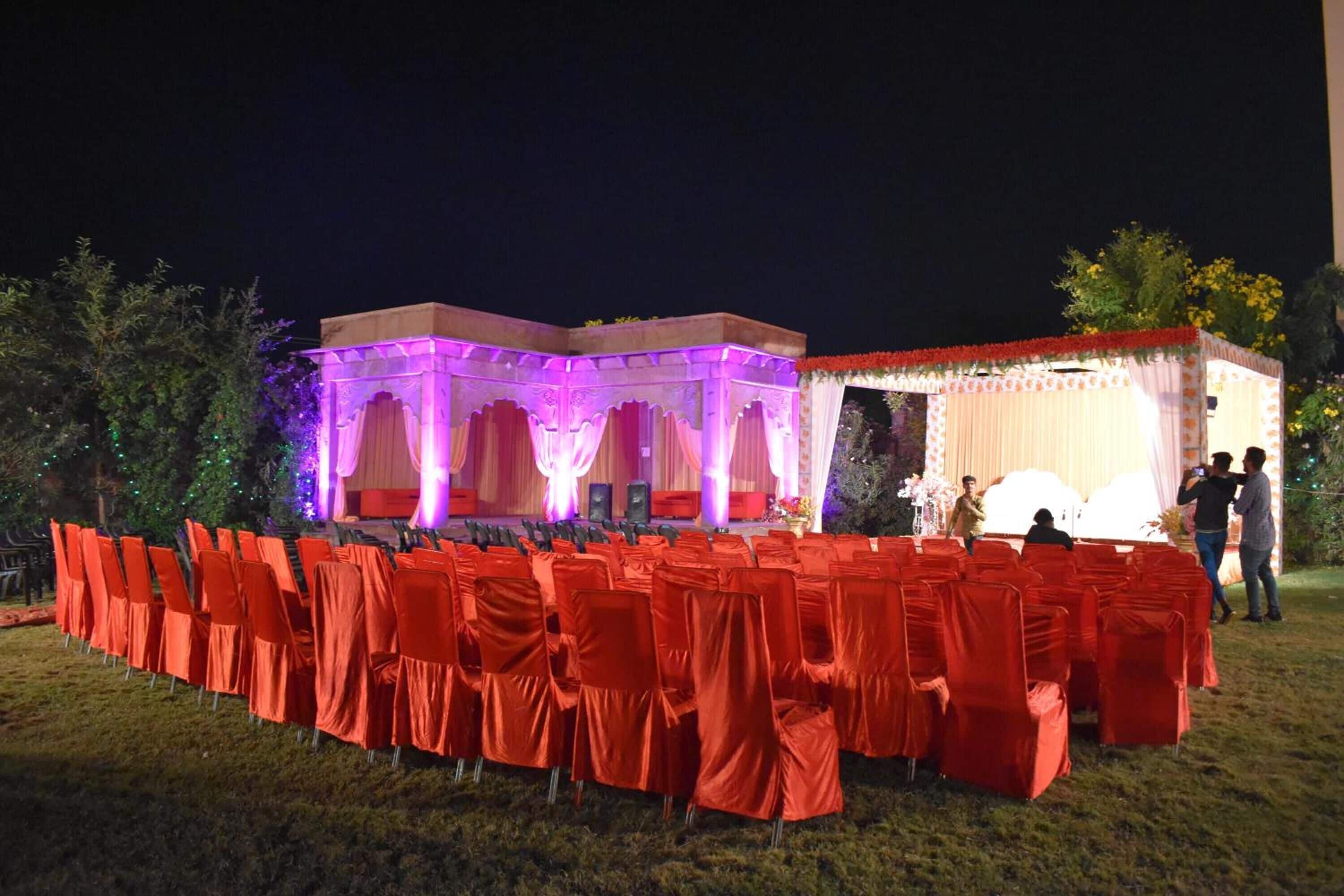 An outdoor event setup with a stage and chairs arranged for an audience.