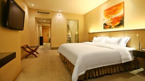 A hotel room with a large bed, a flat-screen TV mounted on the wall, a painting above the bed, and a wooden bench by the door. - Mareka Origin Hotel (Chengdu)