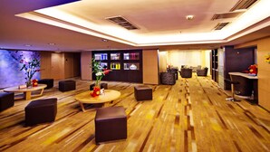 A spacious lobby with a wooden floor, seating areas, a reception desk, and a bar area. - Mareka Origin Hotel (Chengdu)