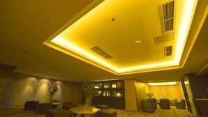 A modern interior with a high ceiling, recessed lighting, and a seating area with sofas and a table. - Mareka Origin Hotel (Chengdu)