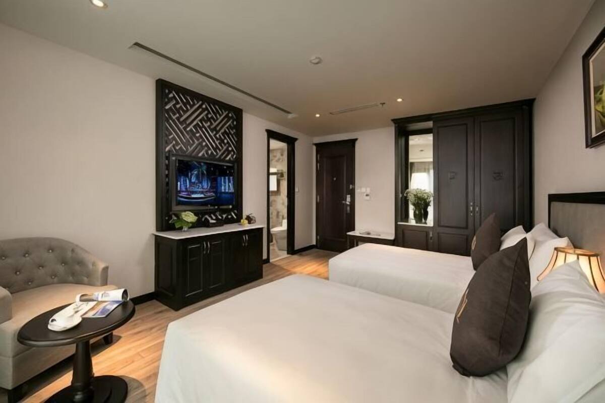 Een hotelkamer met een bed, een televisie, een bureau en een stoel.