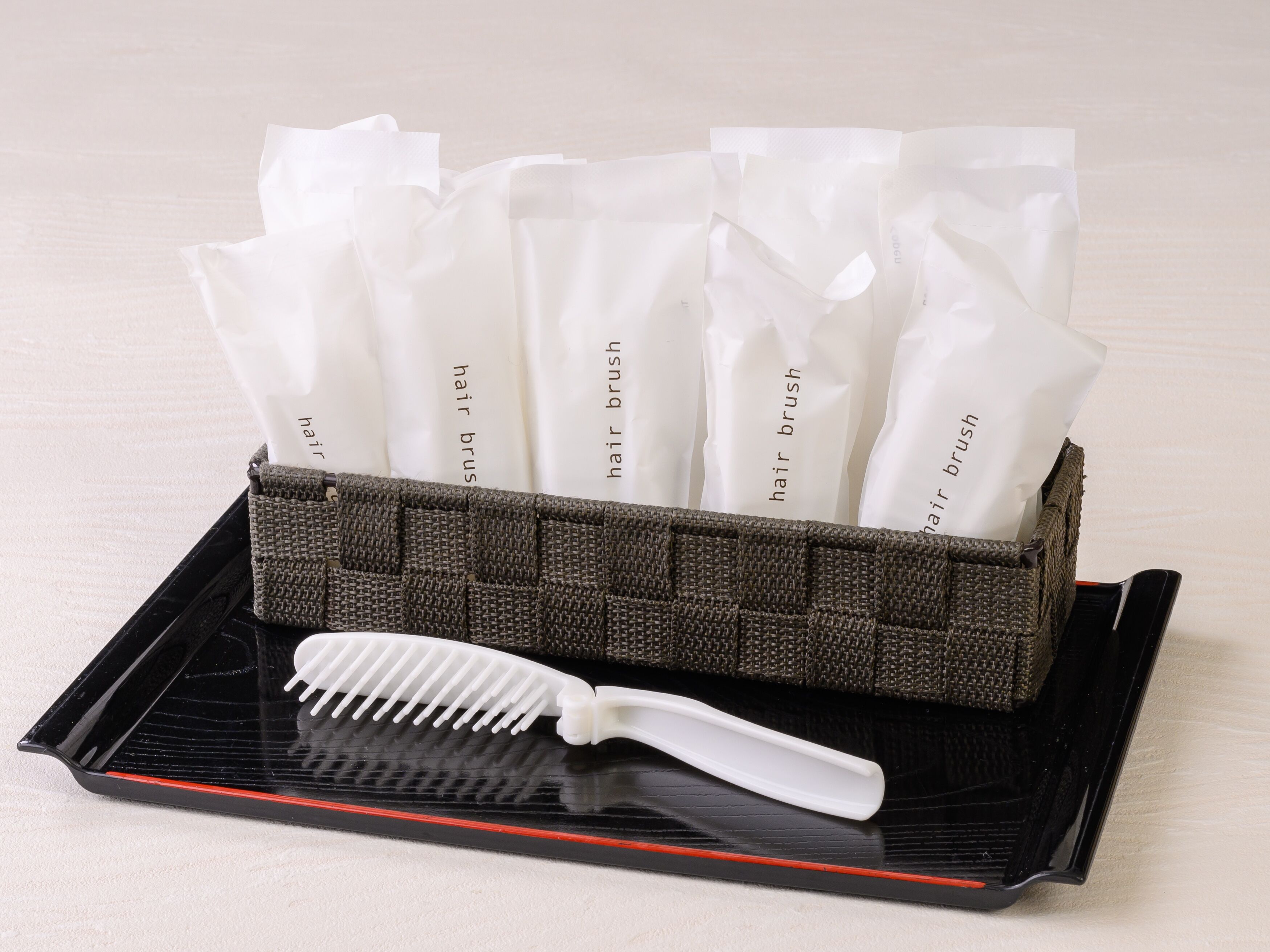 A hairbrush and a woven basket containing multiple hairbrushes.