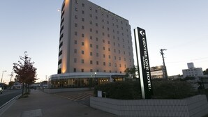 Un hotel de varios pisos con un diseño moderno, que destaca por una entrada imponente y una señalización.