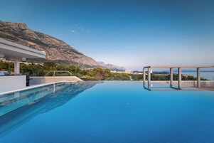 Una piscina al aire libre, sombrillas, tumbonas