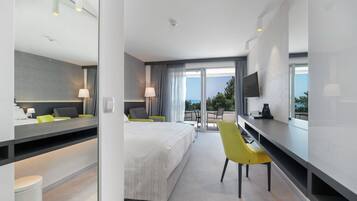 Habitación doble, vista parcial al mar | Minibar, caja de seguridad en la habitación y escritorio