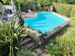 A rectangular swimming pool with a wooden deck and stone steps leading into it. - BIARRITZ in summer, villa golf de BASSUSSARRY heated swimming pool (Bassussarry)