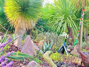 A garden with various plants, rocks, and a sculpture. - BIARRITZ in summer, villa golf de BASSUSSARRY heated swimming pool (Bassussarry)