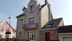 A two-story residential building with a balcony, a garage, and a small attached structure. - Villa Azious, 10 persons, beach side in Wimereux with parking possibility (Wimereux)