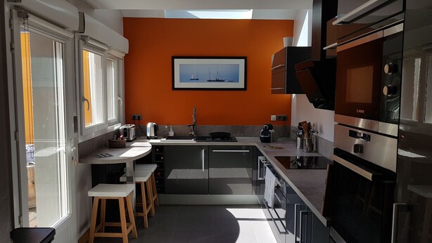 A modern kitchen with a central island, a Bosch oven, and a framed picture on the wall. - Villa Azious, 10 persons, beach side in Wimereux with parking possibility (Wimereux)