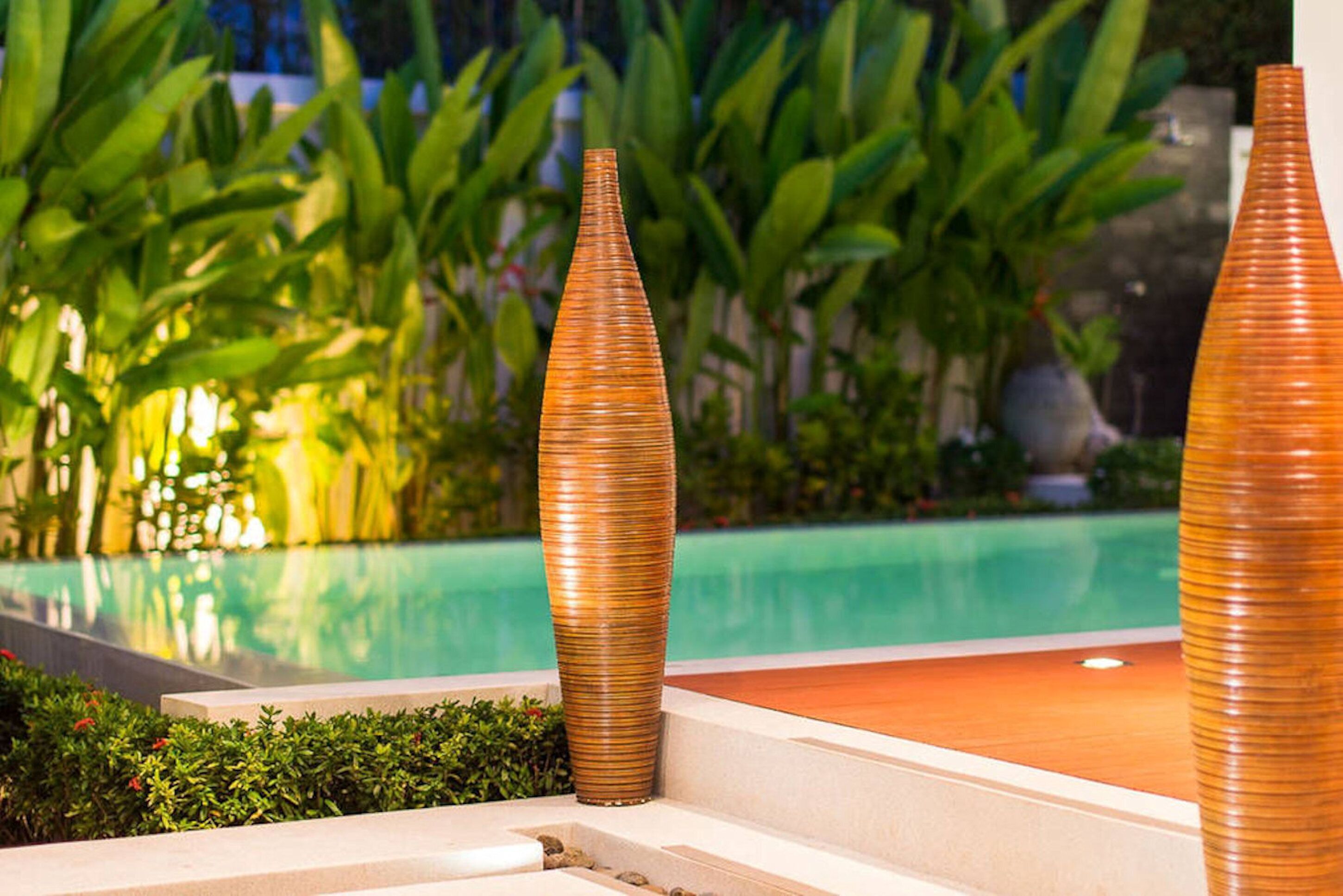 A poolside area with a clear view of the pool and surrounding greenery.