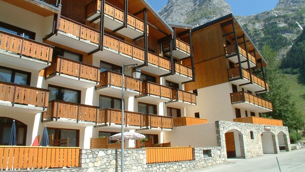 A multi-story hotel with wooden balconies and stone walls. - For rent: Central apartment, 3 rooms, ideal for family (Pralognan-la-Vanoise)