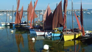 A marina with several sailboats docked, a bridge in the background, and calm water reflecting the boats. - Old house, *** privileged frame, near Pors Carn, the Torch (Penmarch)