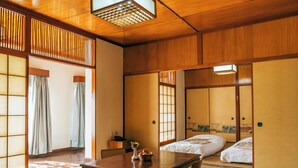 A traditional Japanese room with tatami flooring, a low wooden table, and sliding doors. - Lumbini Hokke Hotel (Sauraha Pharsatikar)