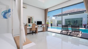 Habitación de hotel moderna con un ventanal grande, un escritorio, una silla, una cama y vistas a una piscina.