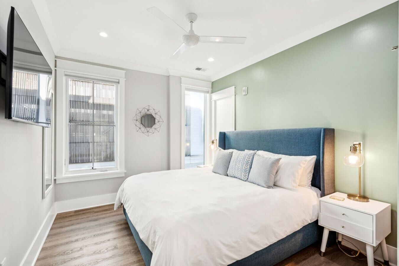 A bedroom with a bed, nightstand, and a ceiling fan.