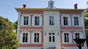 A two-story building with a symmetrical facade, large windows with shutters, and a central entrance. - Manoir De Tireveste (Lesperon)