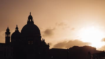 Un grand bâtiment doté de plusieurs dômes et de tours, vraisemblablement un édifice historique ou religieux, avec un coucher de soleil en arrière-plan.