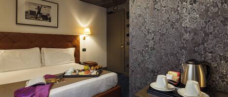 Una habitación de hotel con una cama, una mesita de noche con una bandeja de desayuno, una cafetera y un cuadro en la pared.