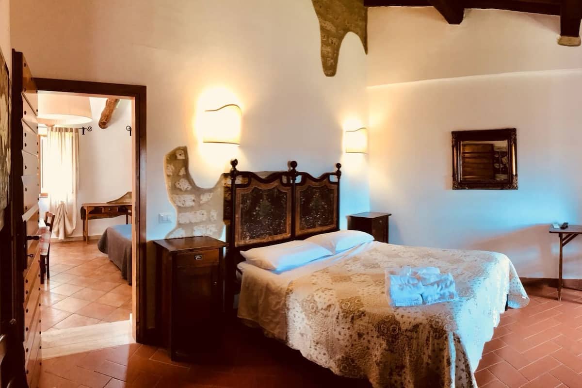 Une chambre à coucher avec un lit, des tables de chevet, un bureau et une chaise.