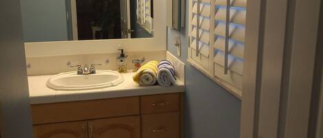 A bathroom with two sinks, a mirror, a towel rack, and a door.