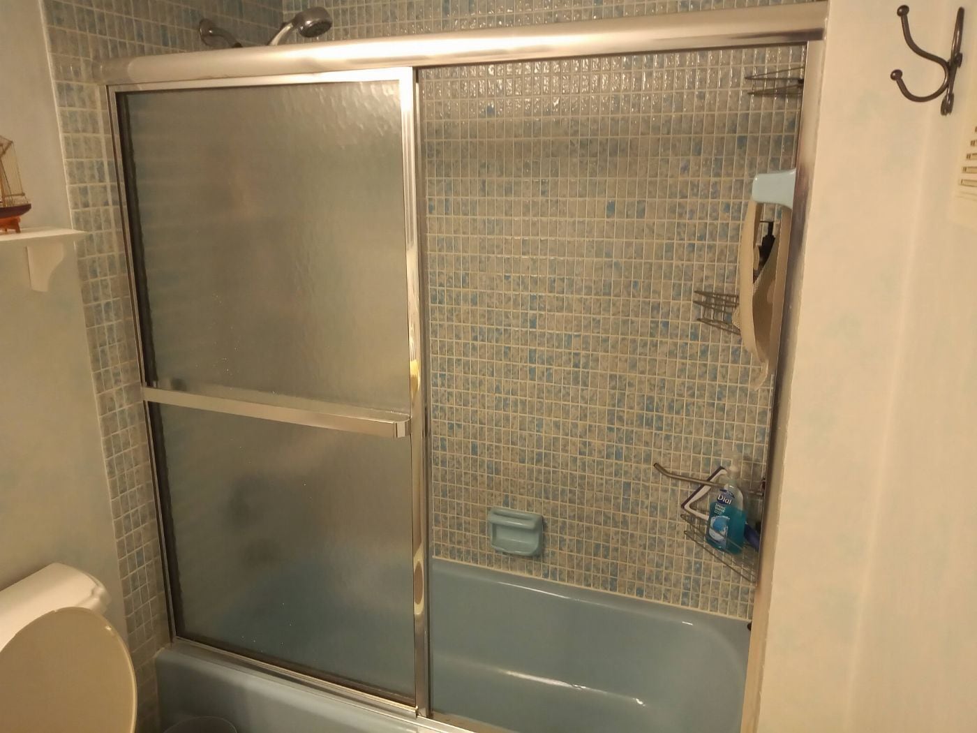 A bathroom with a glass-enclosed shower, a bathtub, and a toilet.