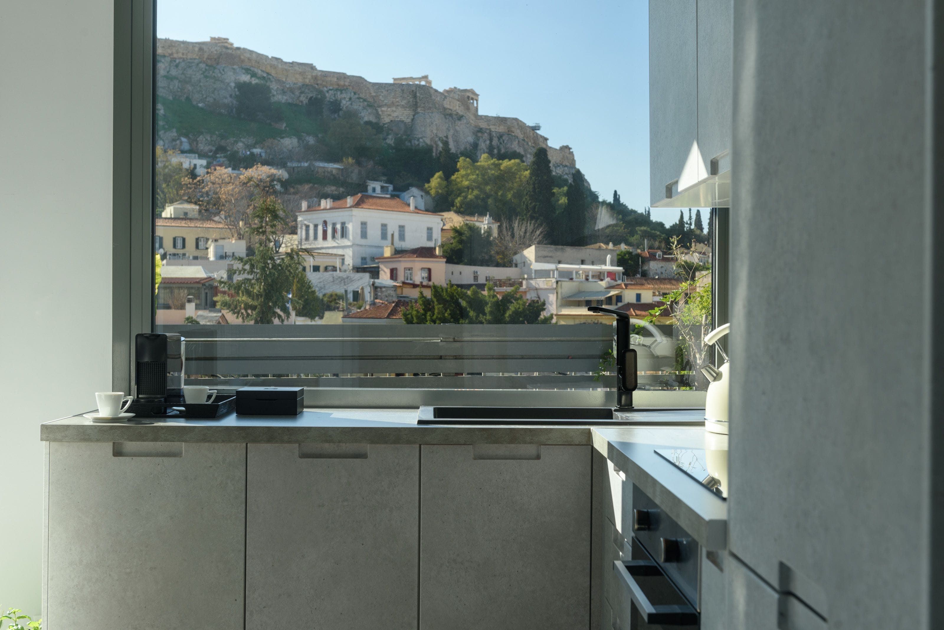 A modern kitchen with a view of a hillside town.