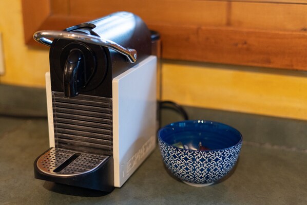 A coffee machine and a patterned bowl on a kitchen counter.
