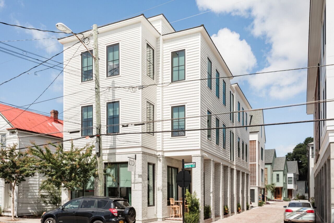 A multi-story building with a flat facade, large windows, and a visible street sign.