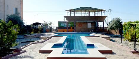 Una piscina al aire libre, sillones reclinables de piscina