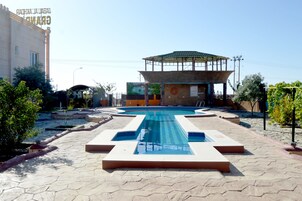 Una piscina al aire libre, sillones reclinables de piscina