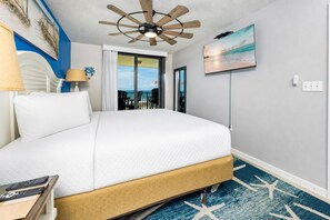 A hotel room with a bed, a ceiling fan, a TV, and a view of the ocean. - Panoramic Views! - Phoenix VII 7513 (Orange Beach)