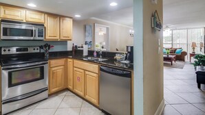 A kitchen with wooden cabinets, stainless steel appliances, and a dishwasher. - Beach Days = Best Days!   Fishing, Sunning, Beaching, Boating, Swimming=FUN!! (Biloxi)