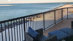 A balcony with wicker furniture and a view of the sea.