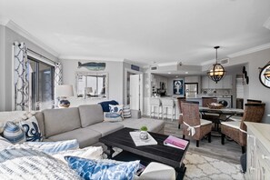 A modern living room with a sofa, coffee table, and dining area.