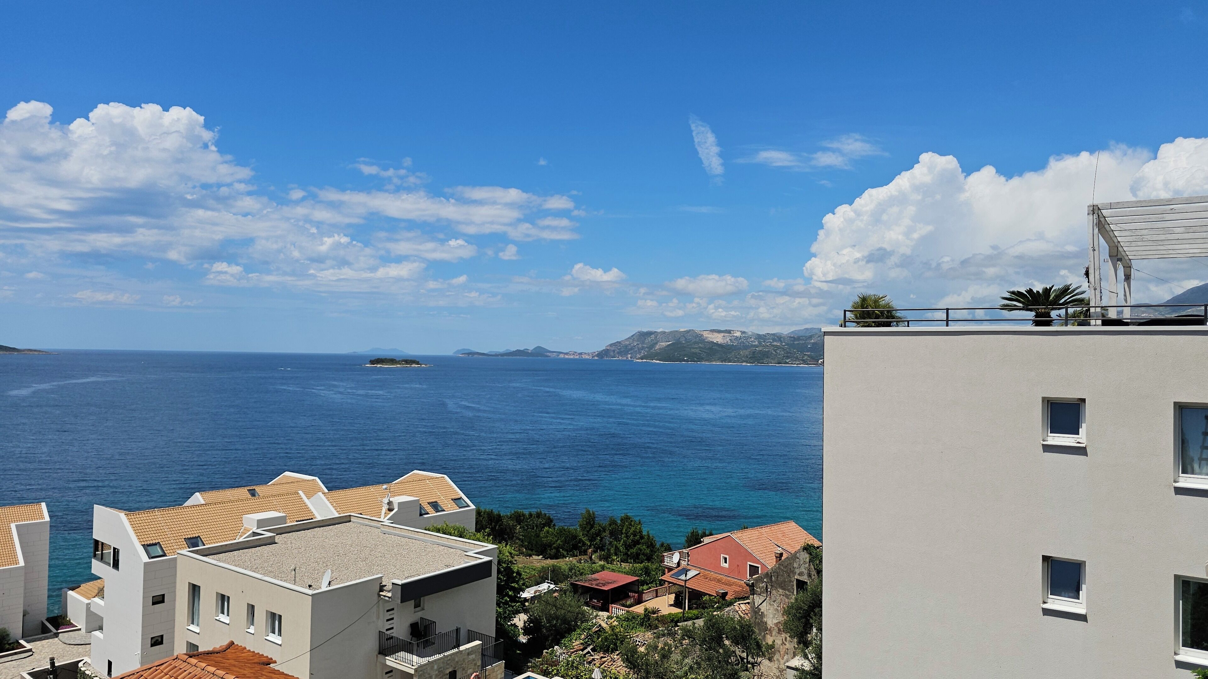 Vista costera con edificios, cielo despejado y el mar.