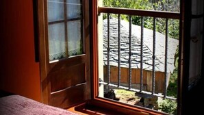 Una habitación con ventana que da a un jardín y una construcción de madera.