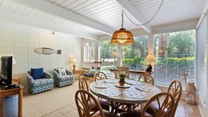 A spacious living room with a round dining table, comfortable seating, and large windows with blinds. - SeaPines, Walk to the Beach Club, Golf view, 2 free bikes (Hilton Head Island)