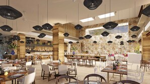 Un restaurante espacioso con varias zonas de comedor, paredes de piedra, lámparas colgantes negras y diversas opciones de asientos.